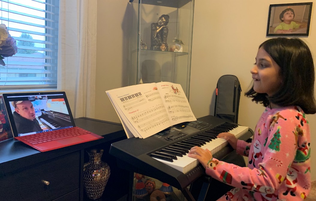 Girl taking her piano lesson online with her instructor in Metairie