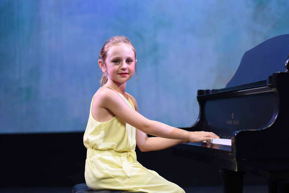 Girl getting ready to play her first notes on the piano